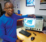 Dr. Chamunorwa Oscar Kureba, postdoctoral research fellow of the Wits HEP Group, with the Tektronix MSO70804C mixed-signal oscilloscope following its successful installation.